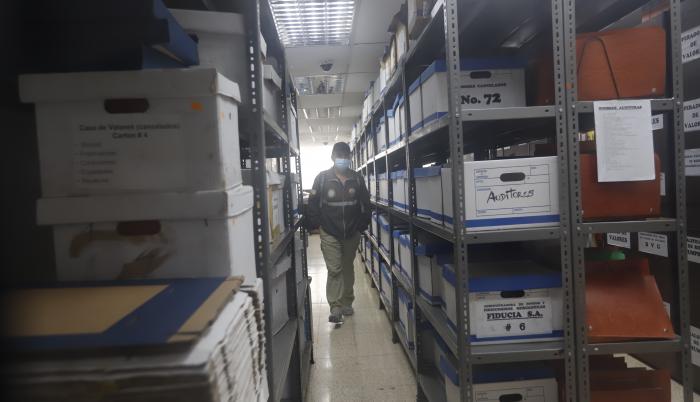 Escena. Un agente fiscal recorre las instalaciones de las bodegas de la Superintendencia de Compañías recopilando información.