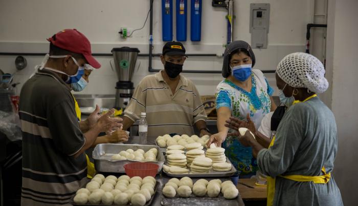 Personas preparan arepas en el marco del Día Mundial de este alimento, hoy, en Caracas (Venezuela).