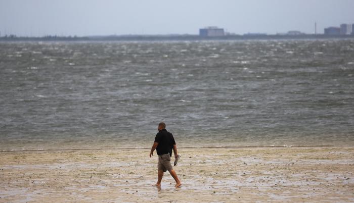 Un hombre camina a lo largo de una costa en Tampa, Florida, EE. UU., el 28 de septiembre de 2022.