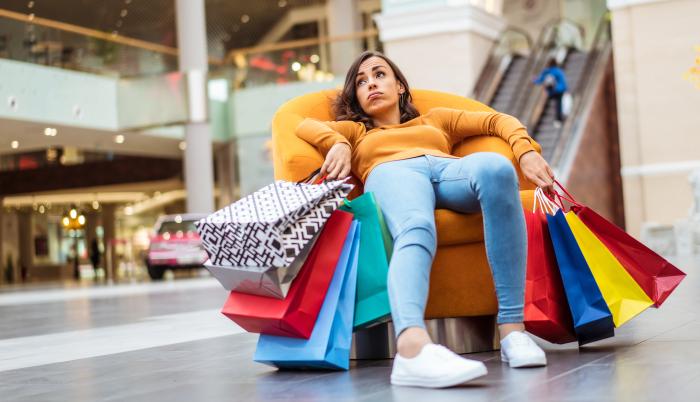 mujer con muchas compras sentada