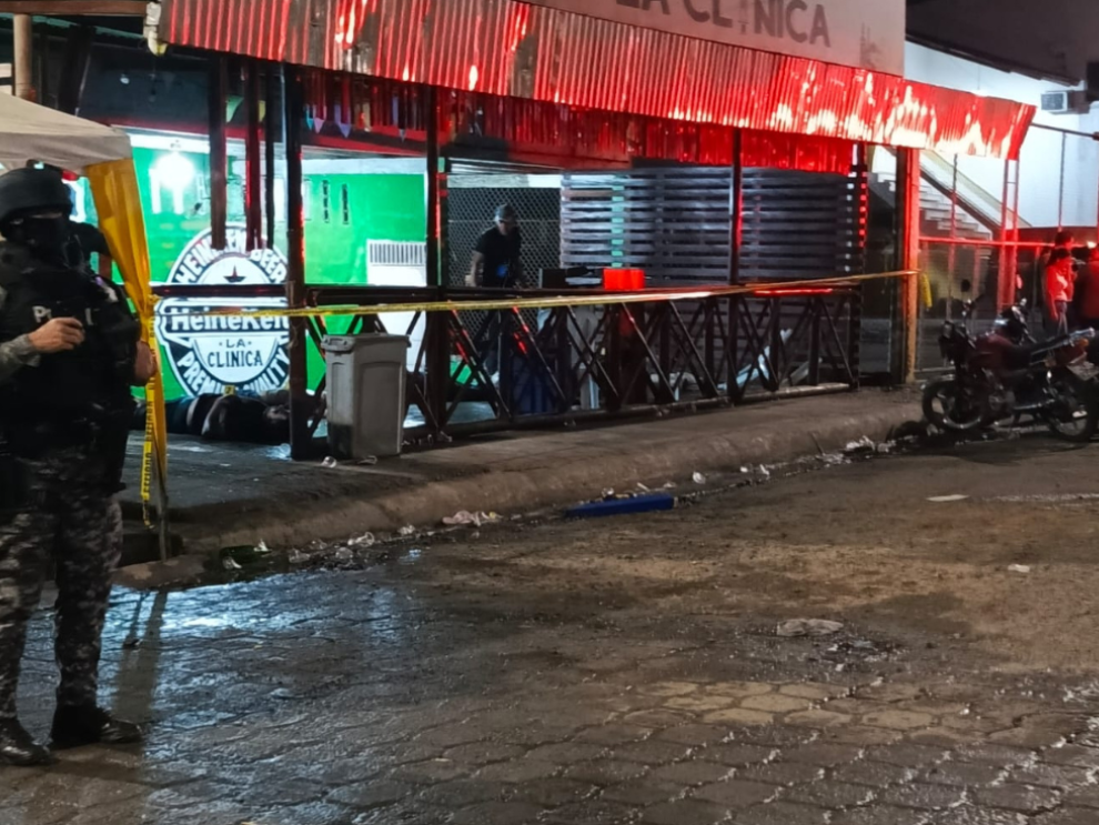 Policía Nacional resguarda la escena tras masacre en distribuidora de licores en El Empalme.