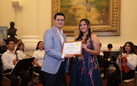 Gonzalo Ortega entrega un reconocimiento a Angie Solano.