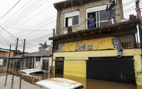 Moradores permancen sobre sus casas inundadas en el barrio Humaita, este domingo en Porto Alegre (Brasil).