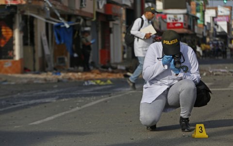 Integrantes de fuerzas de seguridad recogen evidencia en el lugar donde explotó un artefacto este lunes en Jamundí (Colombia).