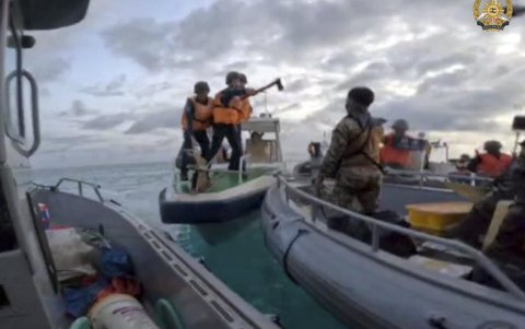 Personal de la Guardia Costera china con un hacha durante una misión de rotación y reabastecimiento de Filipinas al Segundo Thomas Shoal (Ayungin Shoal), el 17 de septiembre.