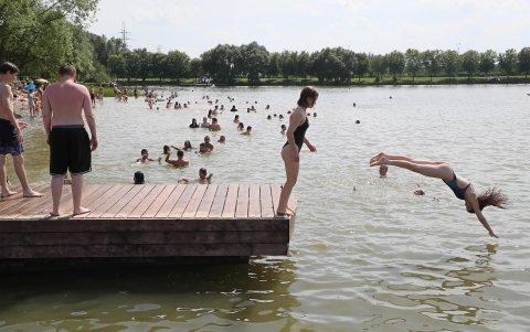 La gente disfruta de un día caluroso en un estanque en un distrito residencial de Moscú, Rusia, el 1 de julio de 2024.