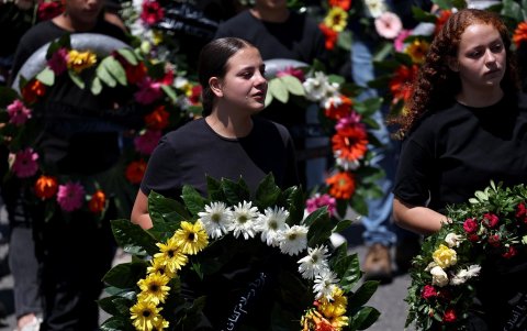 Familiares y amigos de los niños muertos el sábado en un ataque contra una escuela en los Altos del Golán, durante los funerales.