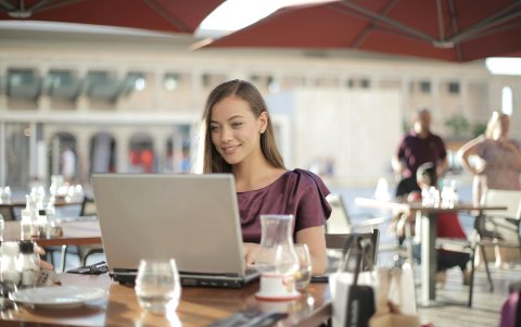 Una joven trabaja desde su casa en una laptop.