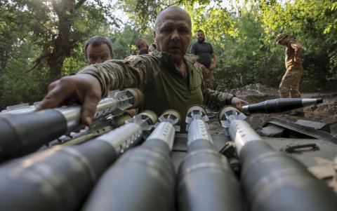 Militares ucranianos de la 24.ª Brigada Mecanizada cargan municiones.
