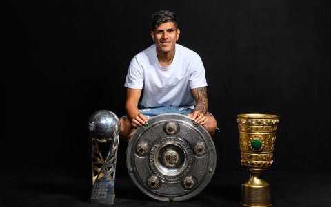 Hincapié posa junto al triplete de títulos: Supercopa (i), Bundesliga (c) y Copa de Alemania.