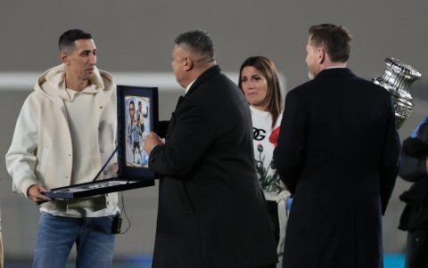 Ángel di María (i) recibe una placa del presidente de la Asociación del Fútbol Argentino (AFA), Claudio 'Chiqui' Tapia (c), junto al presidente de la Conmebol, Alejandro Domínguez (d)