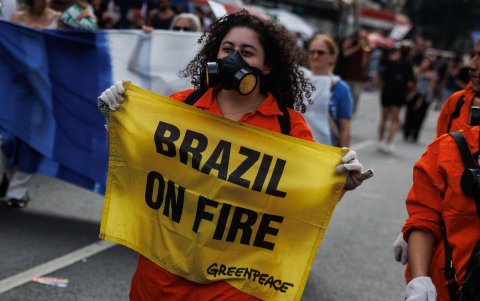 Una mujer que marcha en la Avenida Paulista (Sao Paulo, Brasil) sosteniendo un letrero en una manifestación contra los incendios que afectan a todo el país.