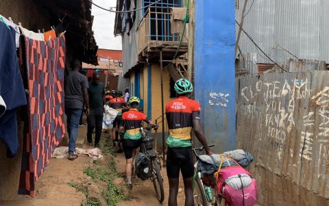 El grupo de la caravana de bicicletas atravesando una de las callejuelas de Kibera, un asentamiento informal situado en Nairobi, para llegar hasta la casa de la ONG Kings and Queens of Kibera.