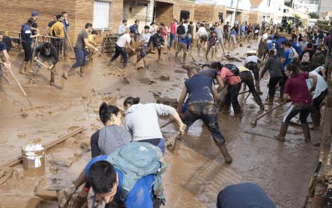 Varias personas colaboran en la limpeza de una calle afectada en la localidad de Utiel, este viernes.