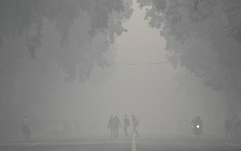 Los peatones cruzan una calle en una mañana fría y llena de contaminación en Nueva Delhi el 18 de noviembre de 2024.