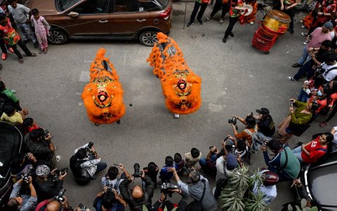 Miembros de la comunidad china toman fotografías durante las danzas tradicionales del dragón y el león, en Calcuta el 29 de enero de 2025, el primer día del Año Nuevo Lunar de la Serpiente.