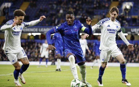 El volante de Chelsea Moisés Caicedo (c) domina el balón en medio de dos jugadores rivales de Copenhague