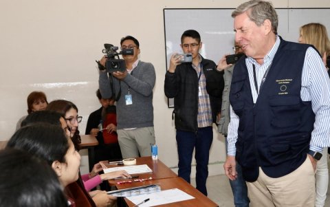 El jefe de la misión de observación electoral de la Unión Europea (UE) en Ecuador, el eurodiputado español Gabriel Mato (d), habla con personas en un centro de votación este domingo en Quito (Ecuador).