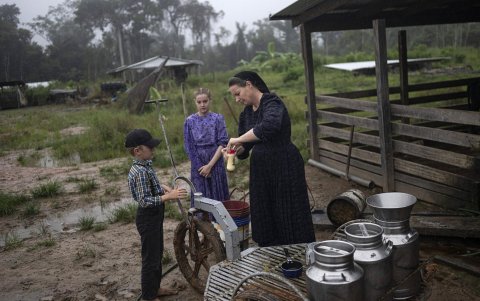Una mujer menonita llena una botella con leche de vaca en la comunidad de Masisea, departamento de Ucayali, Perú, el 21 de marzo de 2025.