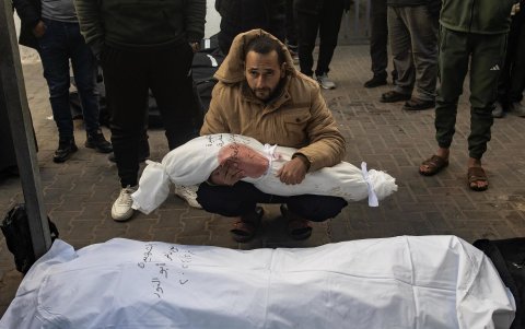 Un hombre sostiene el cuerpo envuelto de una niña mientras los palestinos lloran a sus muertos en el Hospital Al-Najjar tras un ataque aéreo israelí.