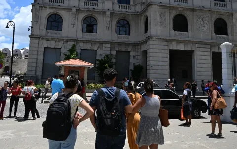 Trabajadores revisan sus teléfonos celulares tras un temblor provocado por un terremoto de magnitud 6.5 en La Habana, el 8 de junio de 2026.