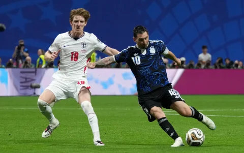 Lionel Messi (d) completa un remate al arco ante los ingleses.