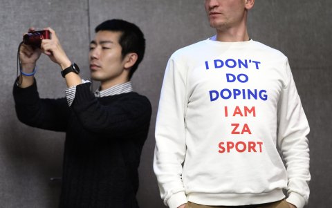 Un periodista usa un suéter que dice 'No dopaje, soy za sport' durante una conferencia de prensa después de la reunión extraordinaria del Comité Ejecutivo de la AMA.