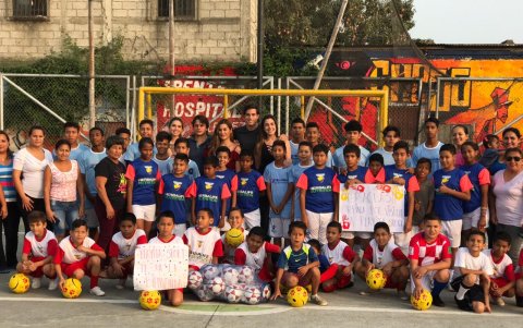 Sofía entregando donación de pelotas de fútbol.