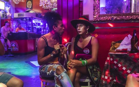 La candidata Gahela Cari (d) conversa con un simpatizante durante una presentación en una discoteca para la comunidad LGTB, en el centro de Lima.