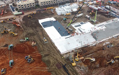 Esta foto aérea muestra excavadoras y camiones en el sitio de construcción de un nuevo hospital que acogerá a los pacientes de un brote mortal en Wuhan.