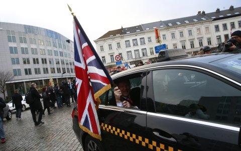 Jonathan Bullock, diputado británico en el Parlamento Europeo, ondea la bandera de su país al abandonar la sede de esa institución en Bruselas, Bélgica.