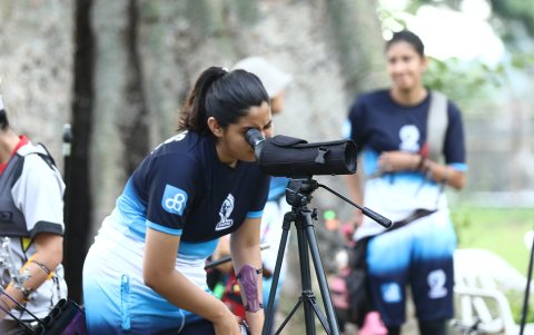 Una de las competidores observa la ubicación de su flecha por medio del binocular.