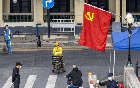 GUANGZHOU. Guardias se distribuyen en diferentes intersecciones de esta ciudad en retenes de control de la temperatura de las personas que transitan camino al trabajo.