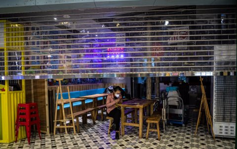 GUANGZHOU. Una mujer espera clientes. Las personas en esta ciudad limitan sus salidas de casa. Los que tienen la oportunidad de trabajar si dejar sus hogares, lo prefieren hacer.