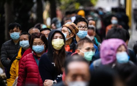 Personas en Hong Kong hacen fila para comprar máscaras faciales en un puesto improvisado.