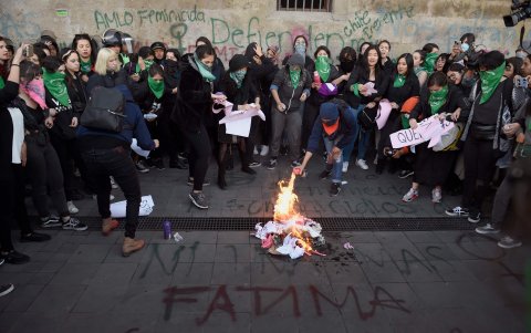 Los manifestantes prendieron fuego en los exteriores del Palacio Nacional, en la Ciudad de México, este martes, para protestar contra la violencia de género.