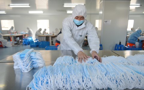 Un trabajador clasifica las máscaras faciales que se producen para satisfacer la demanda durante el brote de coronavirus COVID-19 de China, en una fábrica en Nanjing.