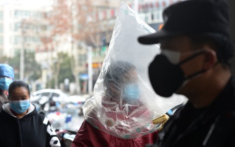 Un residente con una máscara protectora y una bolsa de plástico recorre un supermercado en Wuhan, el epicentro del brote de un nuevo coronavirus, en la provincia central de Hubei.