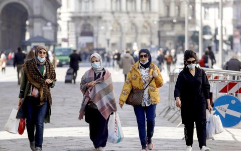 MILAN. Las pocas personas que se atreven a dejar sus casas, tomas medidas. Un grupo camina con mascarillas.