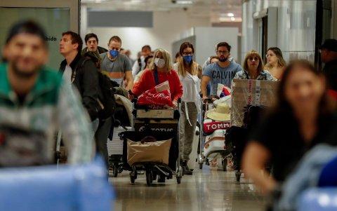 SAO PAULO. Pasajeros usan máscaras como precaución contra la propagación del nuevo coronavirus COVID-19 durante su llegada, hoyjueves, al Aeropuerto Internacional de esta ciudad.