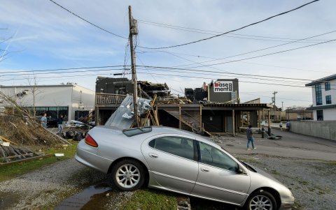 NASHVILLE. Un automóvil aparece movido mientras al fondo se observa la destrucción provocada por los tornados en el entorno urbano de esta población.