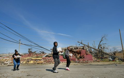 NASHVILLE. Residentes de un barrio de esta ciudad evita los cables de energía sueltos mientras trasladan las pocas cosas que les dejó la tormenta.