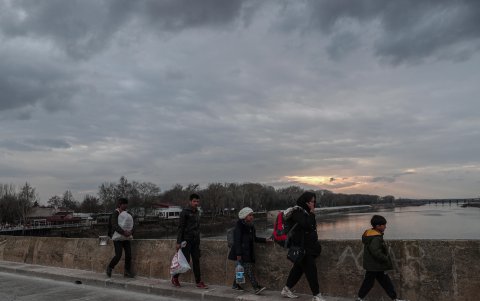 Un grupo de migrantes y refugiados camina hacia la puerta fronteriza de Pazarkule durante la puesta de sol en el centro de la ciudad de Edirne, Turquía.