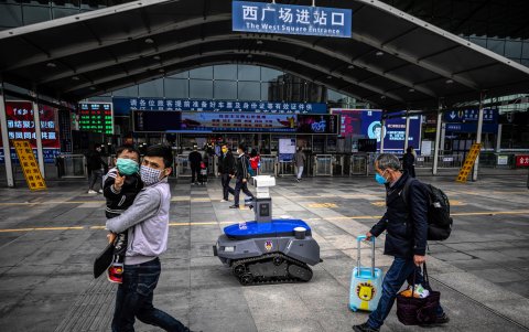 SHENZHEN. Un robot de la policía local da información a las personas que transitan por la plataforma de la estación de ferrocarril de alta velocidad. Es parte de la seguridad policial contra el virus.