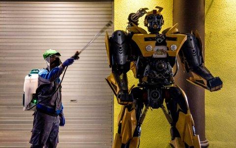 MALANG. Ni los superhéroes se salvan. Un trabajador municipal desinfecta una figura de un transformer en el parque temático de Jatim, en esta ciudad de Indonesia.