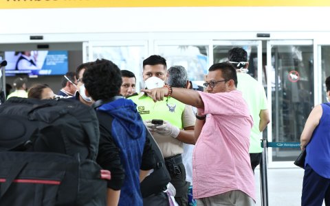 Un agente de la policía toma los datos de un viajero proveniente de Madrid, a quien instó a dirigirse directamente a su domicilio en Guayaquil.
