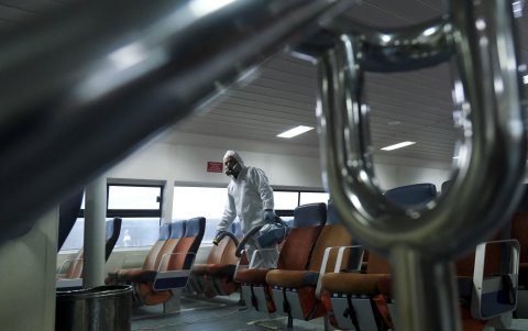 BOGOTÁ. Un grupo de trabajadores disinfectan un bus del servicio urbano.