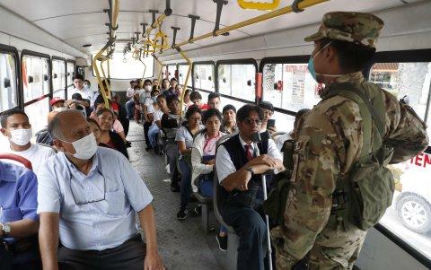LIMA. Militares controlan el desplazamiento de personas en un bus de servicio público este martes, durante el segundo día de Estado de Emergencia decretado por el presidente de Perú, Martín Vizcarra.
