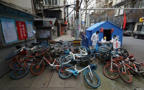 WUHAN. Un montón de bicicletas instaladas como barrera improvisada junto a una estación de control de temperatura en la entrada de una comunidad residencial. Las barricadas persisten.