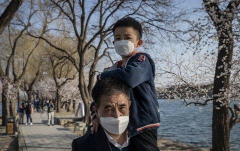 PEKÍN. Un padre con su hijo caminan por uno de los parques de la capital del gigante asiático, en un día que parece normal, pero que aún no lo es. Las mascarillas lo recuerdan.